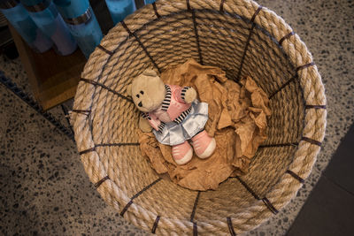 High angle view of teddy bear lying in a straw basket