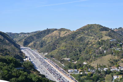 High angle view of road amidst trees against clear sky