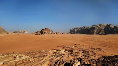 Scenic view of desert against clear blue sky