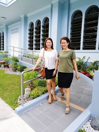 Portrait of smiling woman standing against plants