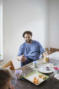 Man sitting at table and having snack