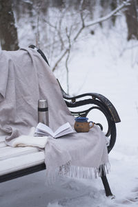 Rear view of man sitting on snow covered field