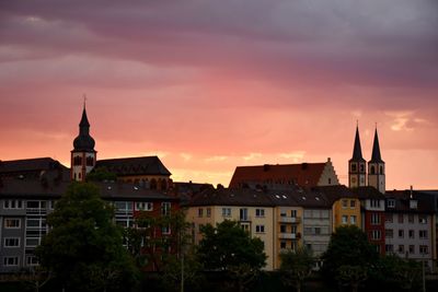 Buildings in town against sky at sunset