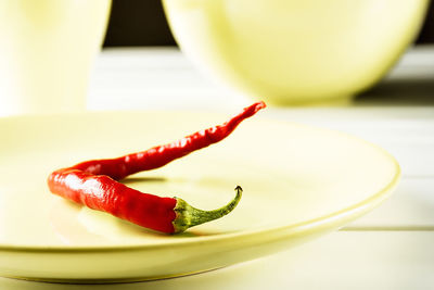 Close-up of red chili peppers in plate on table