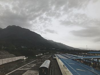 Aerial view of road by mountains against sky