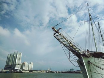 Low angle view of cranes at harbor