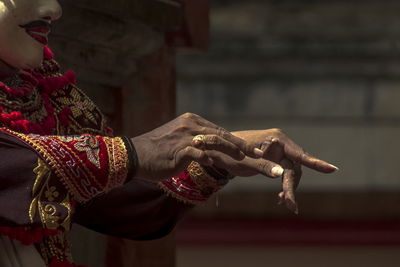 Midsection of mask dance holding sculpture