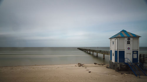 Hut on beach against sky