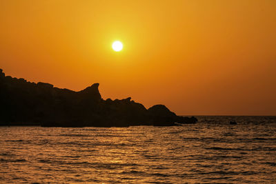 Scenic view of sea against orange sky