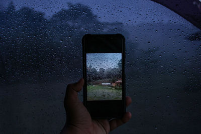 Cropped image of hand holding mobile phone