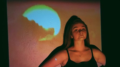 Portrait of woman standing against wall