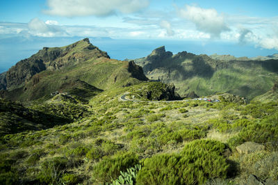 Scenic view of green mountains against sky