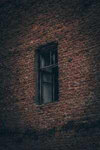 Low angle view of window on wall of old building