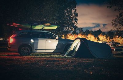 Car and tent on field at night