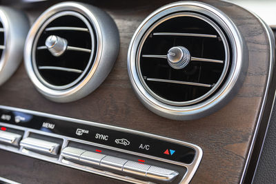 The interior of a modern passenger car with three vents visible and air conditioning control.