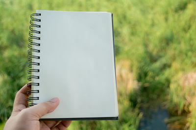 Midsection of person holding book