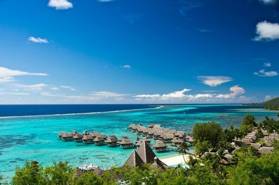 Scenic view of stilt houses in sea at moorea against sky