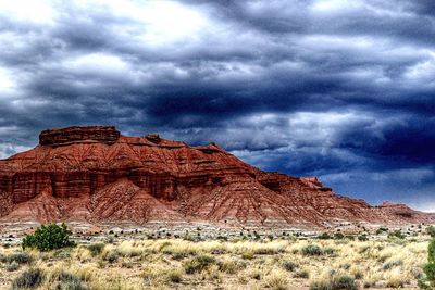 View of rock formations on landscape against cloudy sky