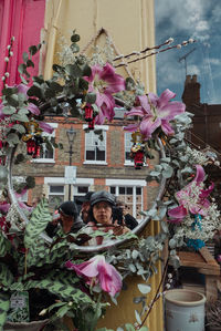 Portrait of pink flowering plant against building