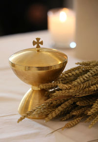 Close-up of golden container with wheat crops on altar in church
