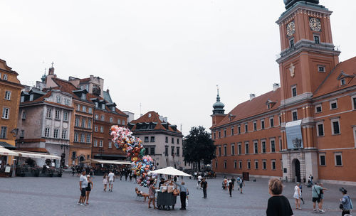 People on street buy baloon in colorfull city 