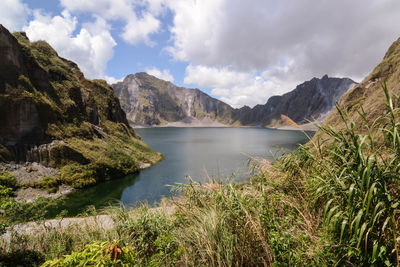 Scenic view of lake by mountains against sky