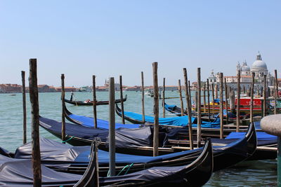 Gondolas moored in grand canal against clear sky