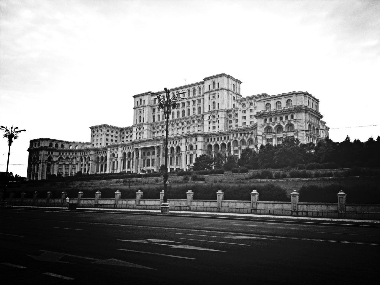 architecture, built structure, building exterior, transportation, road, city, street, history, sky, travel destinations, travel, famous place, incidental people, car, arch, facade, building, outdoors, capital cities, road marking