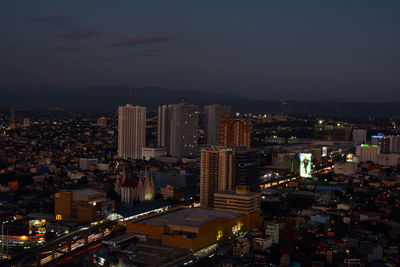 High angle view of illuminated buildings against sky at night