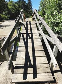 Wooden footbridge on footpath during sunny day