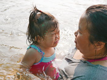 Rear view of mother and daughter at beach