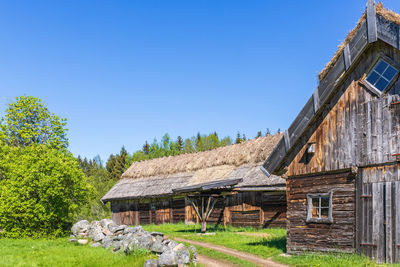 House on field against clear blue sky