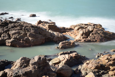 Scenic view of sea by cliff against sky