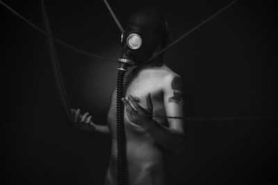 Man wearing gas mask in darkroom