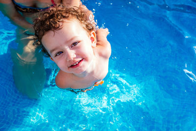 High angle portrait of shirtless baby girl standing in swimming pool