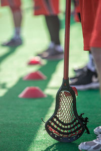 Low section of man with sports equipment on lacrosse field