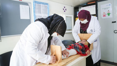 A doctor measures the height of a little girl. malnutrition in children. person