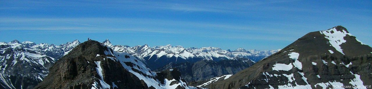 PANORAMIC SHOT OF SNOWCAPPED MOUNTAINS AGAINST BLUE SKY