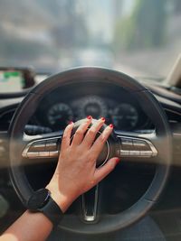 Cropped hand of man driving car