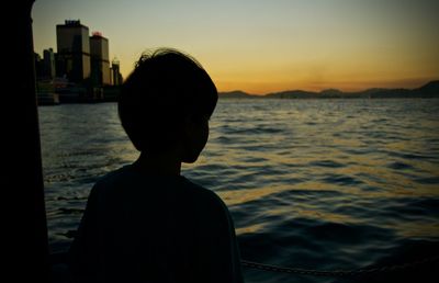 Woman looking at city at sunset