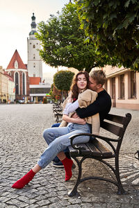 Happy woman sitting with arms raised