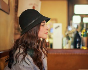 Side view of young woman wearing hat