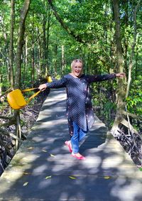 Portrait of smiling woman against trees