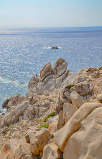 Rock formation on beach against sky