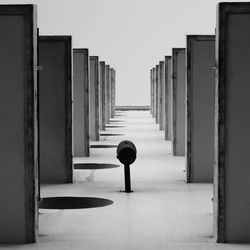 Rear view of corridor on building against sky