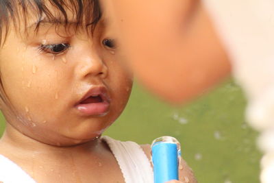 Close-up portrait of cute boy drinking water