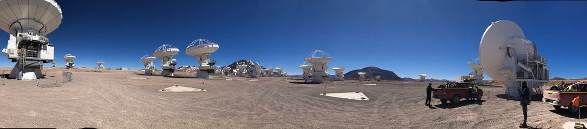 Group of people in front of buildings against blue sky
