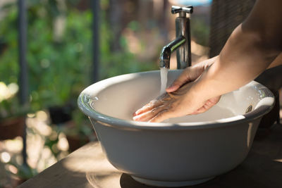 Midsection of person holding glass with water