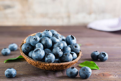 Fresh blueberries in a bowl on a wooden table. organic wild superfood