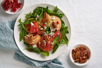 Fruits citrus salad with nuts, green lettuce leaves. balanced food. spinach with orange, grapefruit